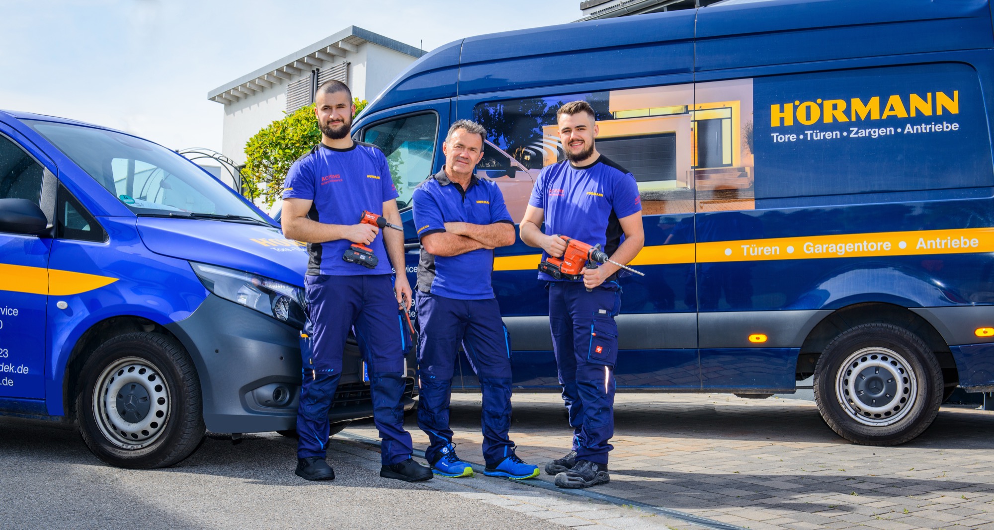 Das Team von Achims Montage und Hausmeisterservice vor den Hörmann-Servicefahrzeugen in Erlangen